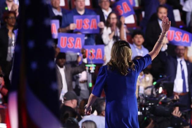 Silhouette shot of woman on stage with crowd in the background.