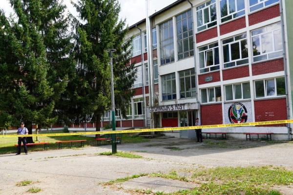 Police officers stand guard outside the building of a high school wher<em></em>e a man opened fire killing three staff members