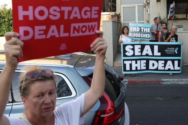 A protester carries a poster during a gathering calling for the release of Israelis