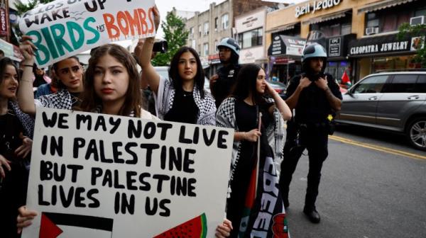 people hold palestinian flags at a protest