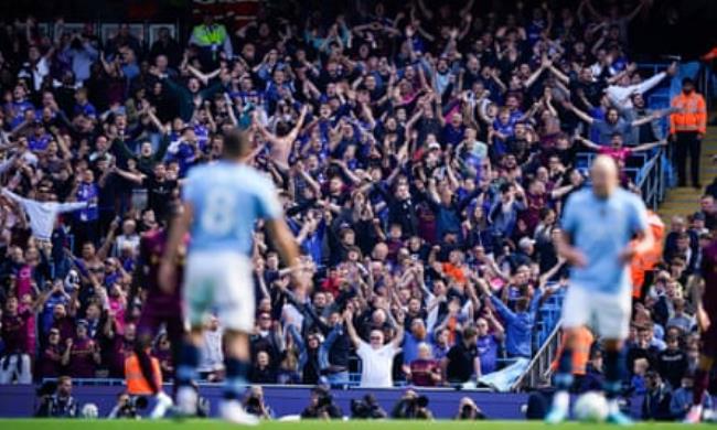 Ipswich fans celebrate in the background of some Manchester City players.